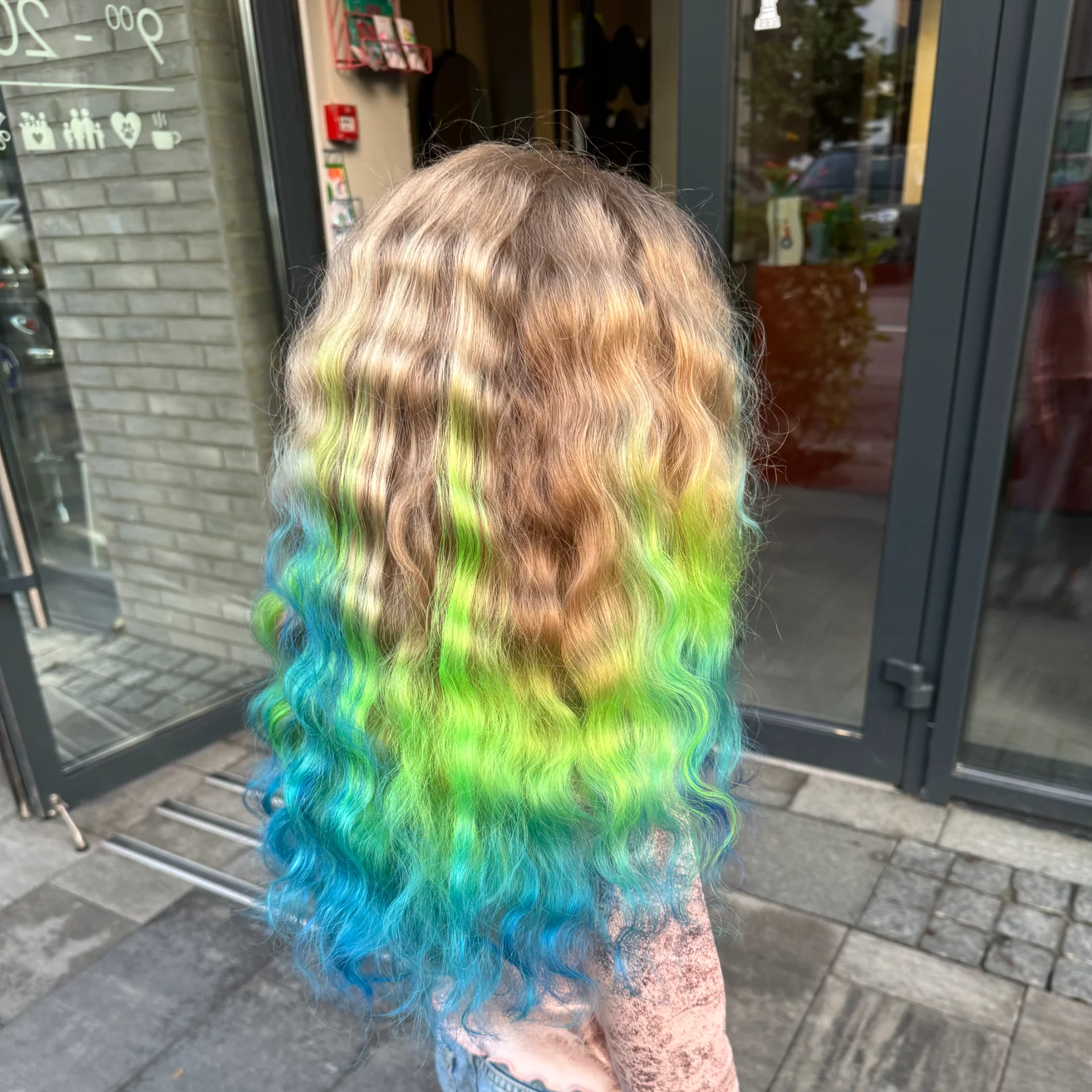 A child's hair being colorfully highlighted, capturing joy and creativity.